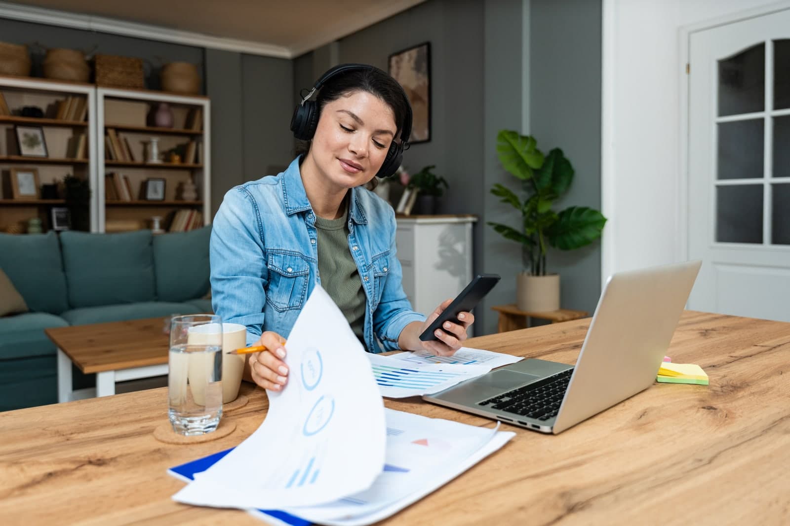 Neurodivergent professional wearing headphones focusing at work with laptop and documents